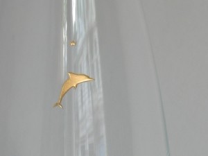 Glaskaraffe mit kleiner vergoldeter Gravur eines Delfins mit darüber schwebendem Krönchen