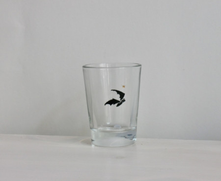 Fledermaus, Gravur auf Glas mit schwarzer Farbe eingelegt, darüber ein kleines goldenes Krönchen.