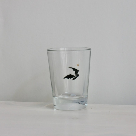 Fledermaus, Gravur auf Glas mit schwarzer Farbe eingelegt, darüber ein kleines goldenes Krönchen.