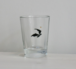 Fledermaus, Gravur auf Glas mit schwarzer Farbe eingelegt, darüber ein kleines goldenes Krönchen.