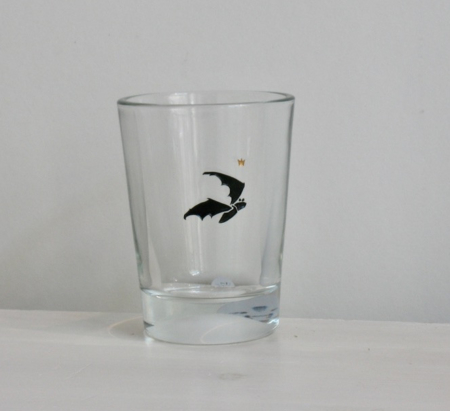 Fledermaus, Gravur auf Glas mit schwarzer Farbe eingelegt, darüber ein kleines goldenes Krönchen.