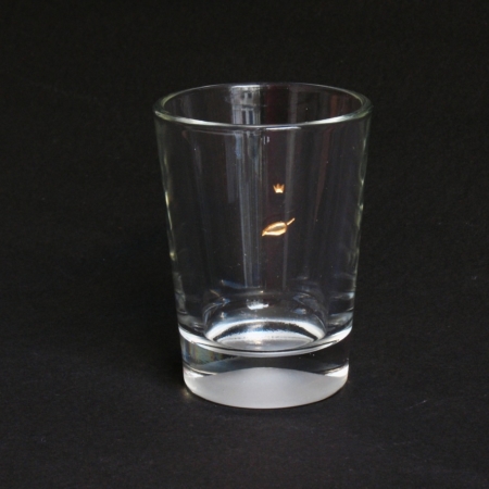 goldenes Blatt auf leichter Briese segelt dahin. Glasgravur auf kleinem Becher, farbvergoldet